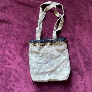 9 1/2x 9 1/2 cloth purse w/ fringes at the top and bottom.